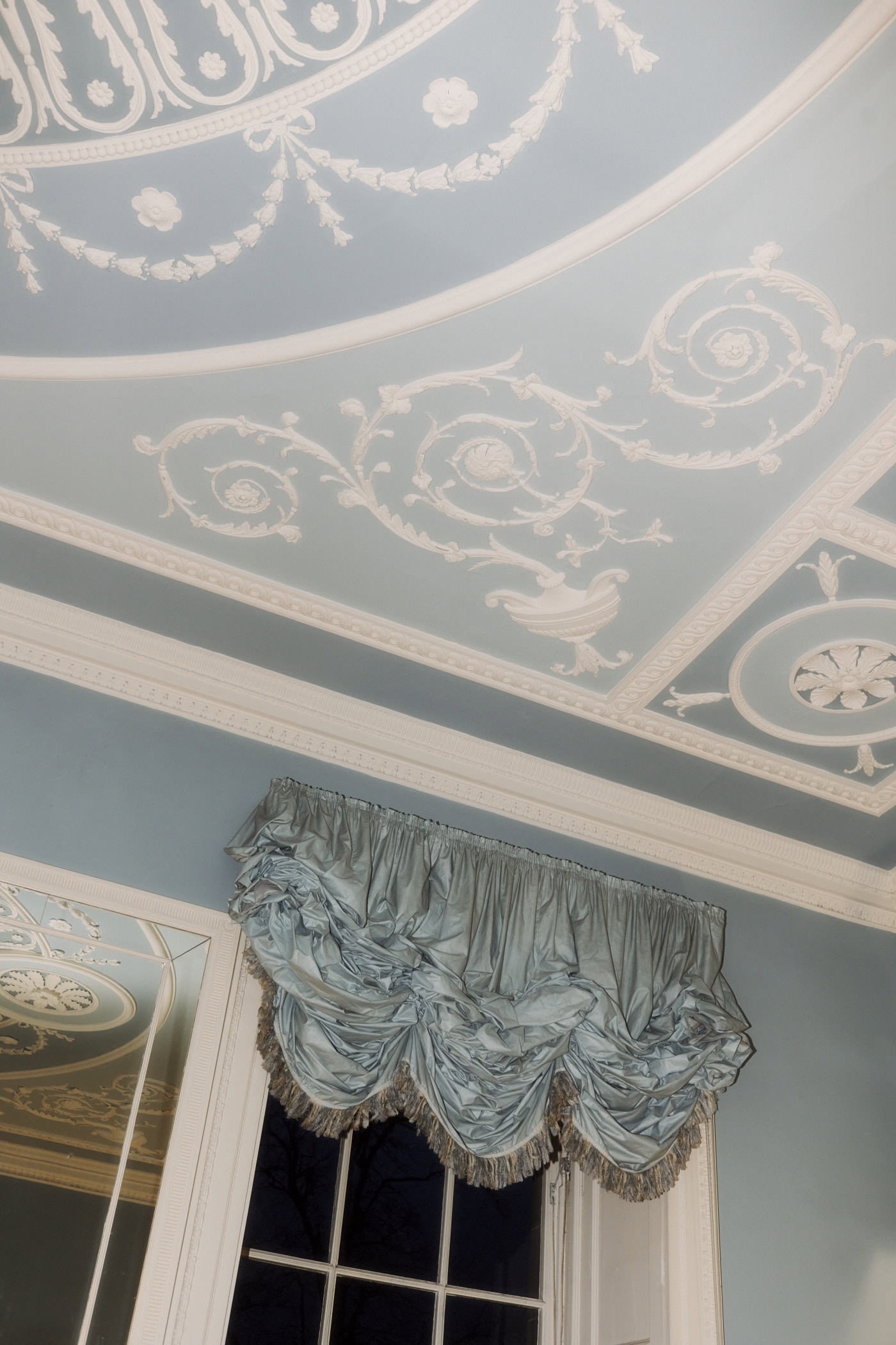 Ornate plasterwork ceiling and swagged silk curtains in the Cullen Suite at the Royal College of Physicians of Edinburgh
